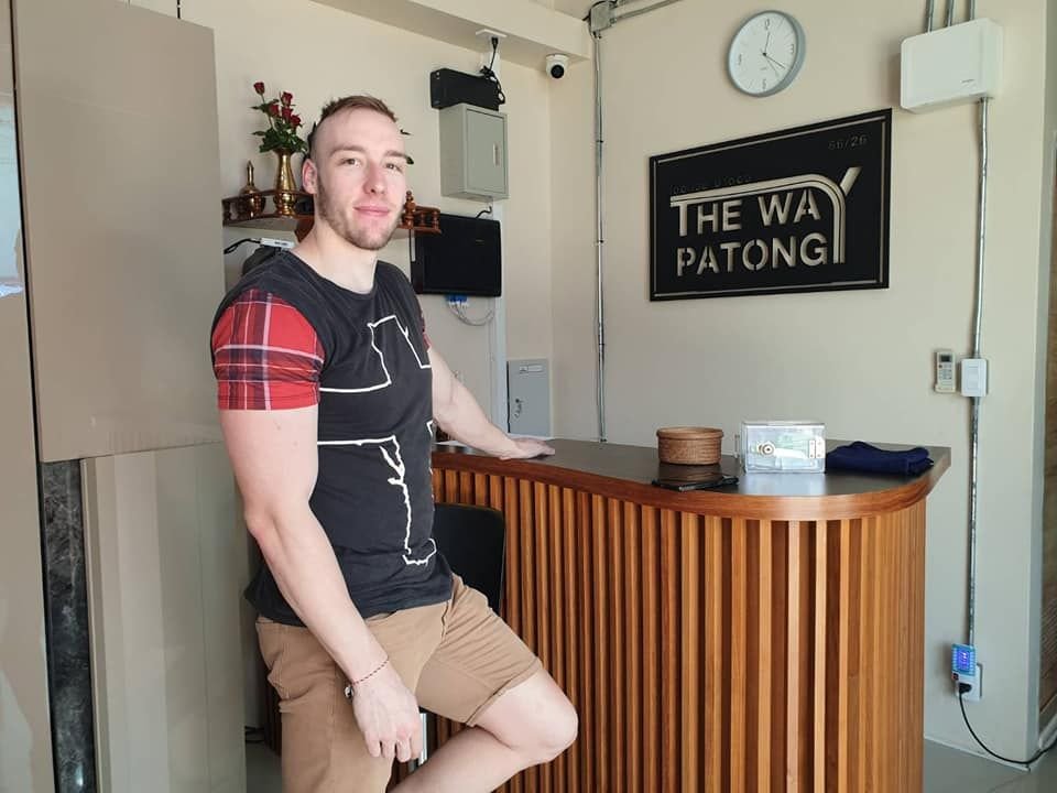 Guest leaning on the reception desk at The Way Patong Hotel