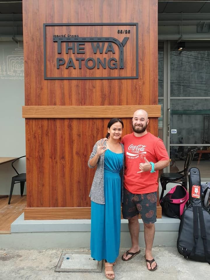 Couple in front of The Way Patong Hotel sign