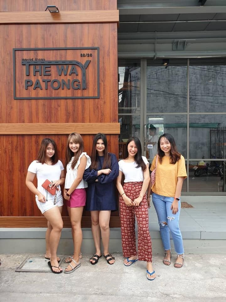 Five friends posing in front of The Way Patong Hotel sign