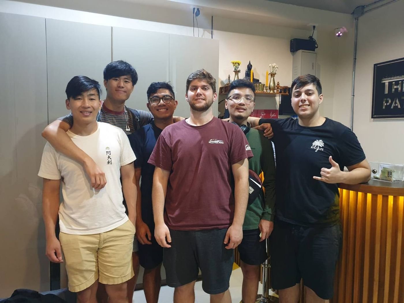 A group of six smiling guests at the reception of The Way Patong Hotel
