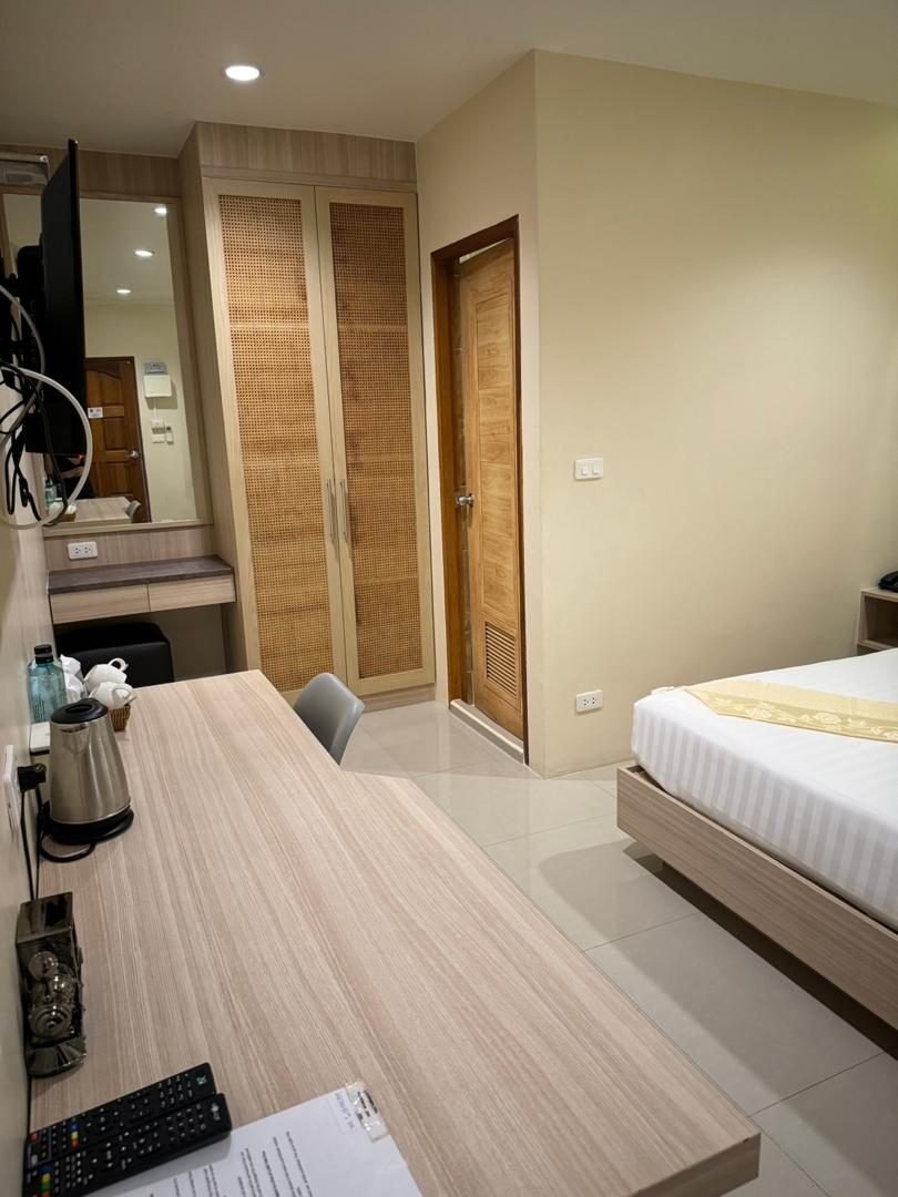 Long laptop-friendly desk and wardrobe in a guest room at The Way Patong Hotel