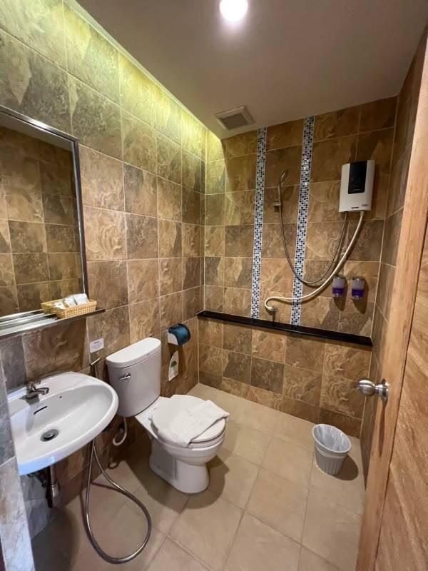 Private bathroom with hot-water shower, toilet and basin at The Way Patong Hotel