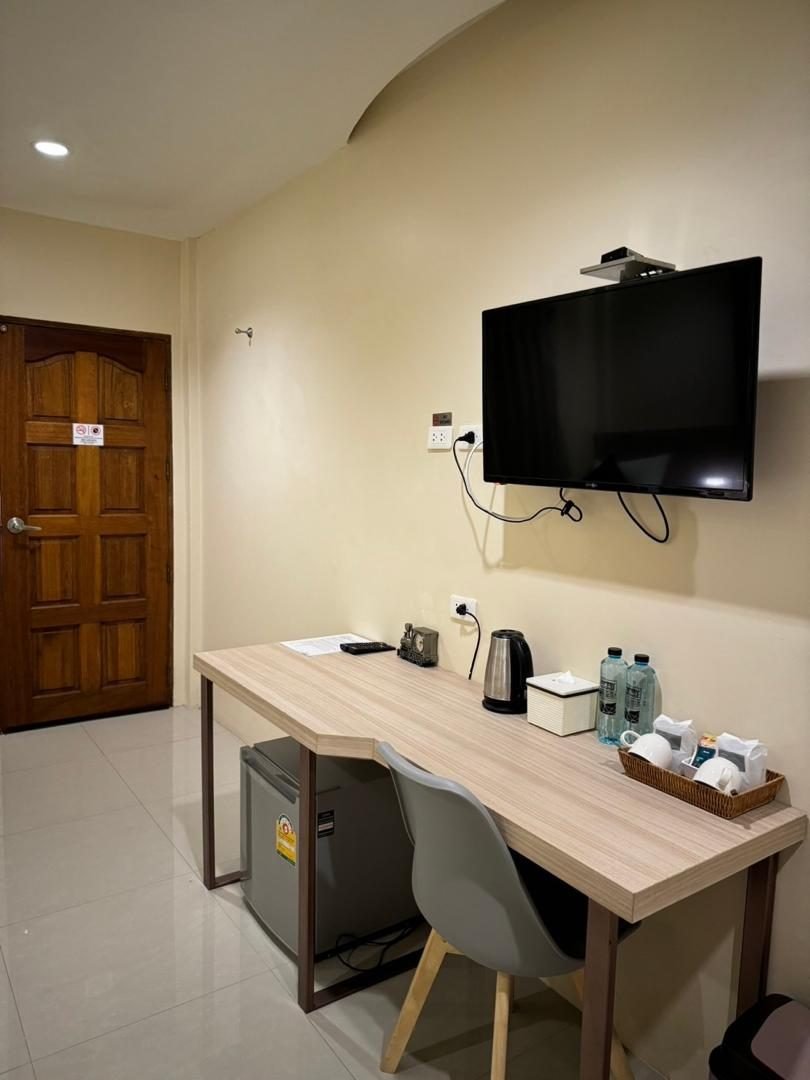 Work desk with chair, kettle, mini fridge and wall-mounted flat-screen TV in a room at The Way Patong Hotel